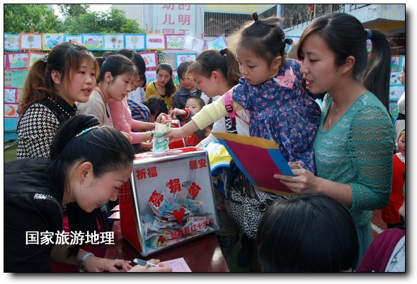 4月27日，婺源縣星星幼兒園的小朋友們?cè)诩议L(zhǎng)的陪同下將愛(ài)心義賣的錢進(jìn)行募捐。